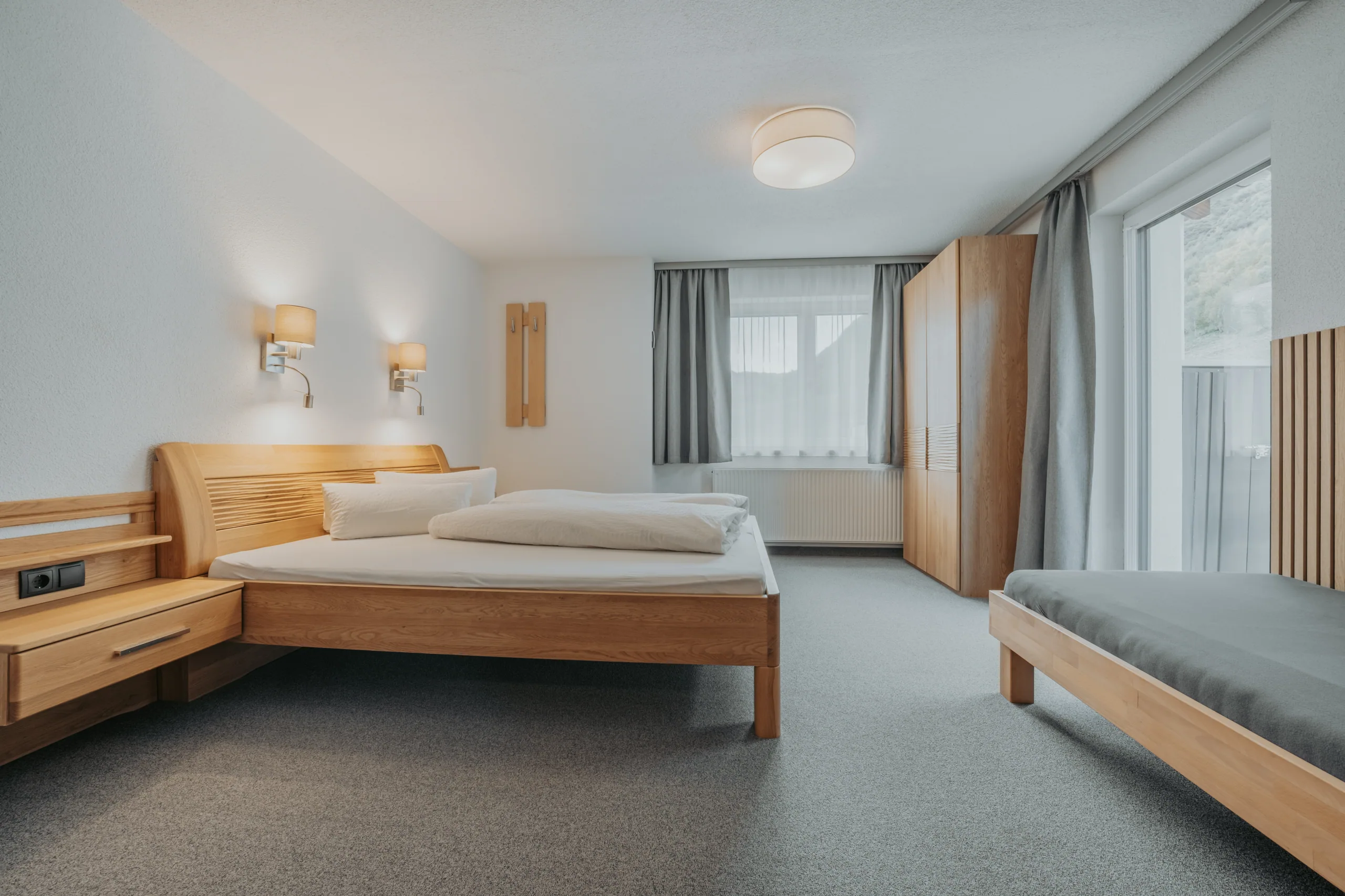 Doppelzimmer mit Holzbett und Sitzbank in Wohnung 2