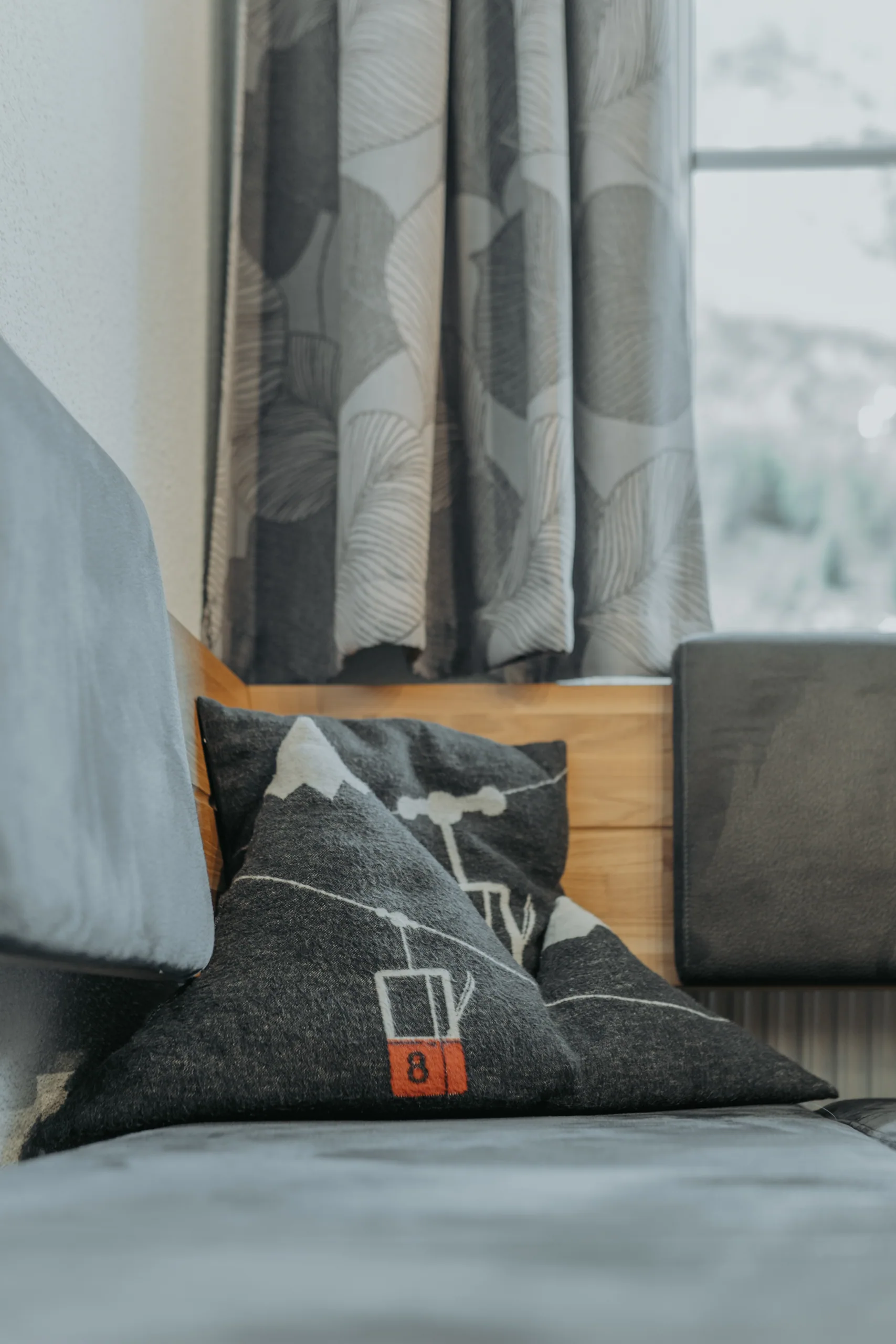Kissen und Holzdetail an der Sitzbank in Wohnung 2