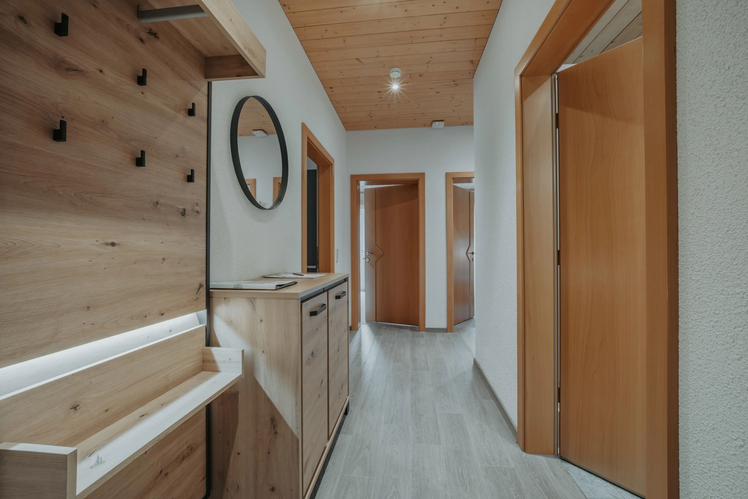 Flur mit Holzverkleidung und Garderobe in Wohnung 3