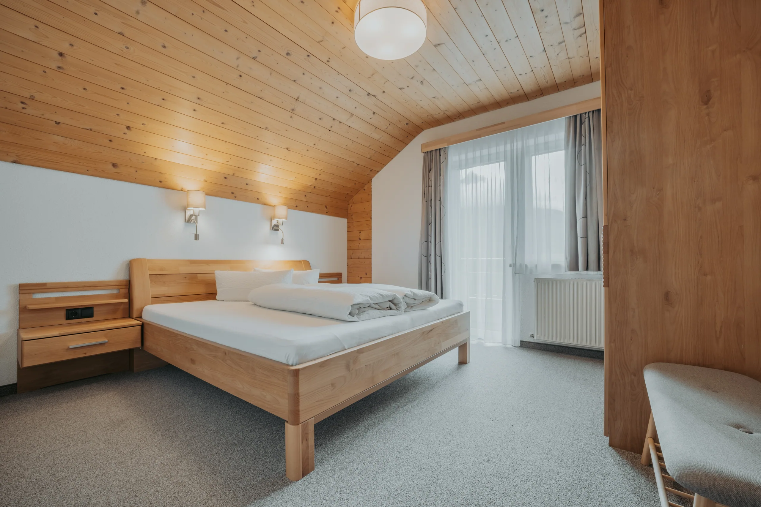 Doppelzimmer unter der Holzdecke in Wohnung 3